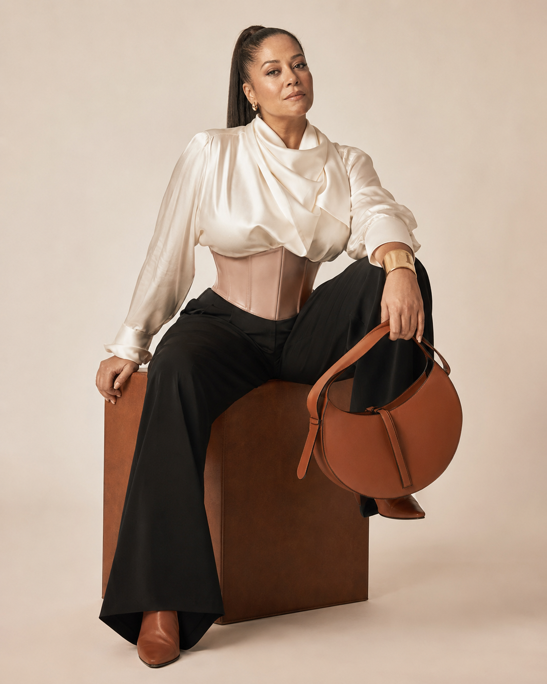 Woman in ivory silk black trousers and blush leather corset