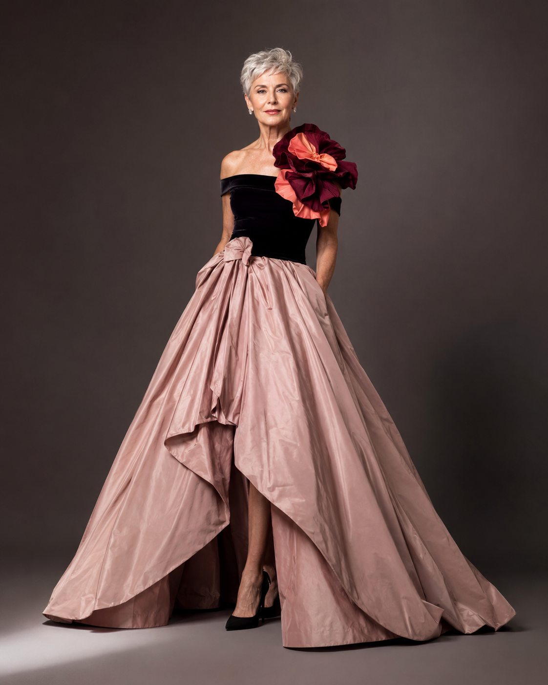 Silver-haired woman in a dramatic blush and black gala look